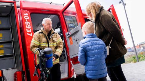Brandweerman geeft informatie aan vrouw en kind