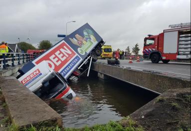 Brandweer trekt vrachtwagen uit het water in Oudendijk