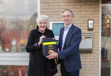 Burgemeester Hafkamp en directeur van de VRNHN Martin Smeekes houden de duizendste AED vast